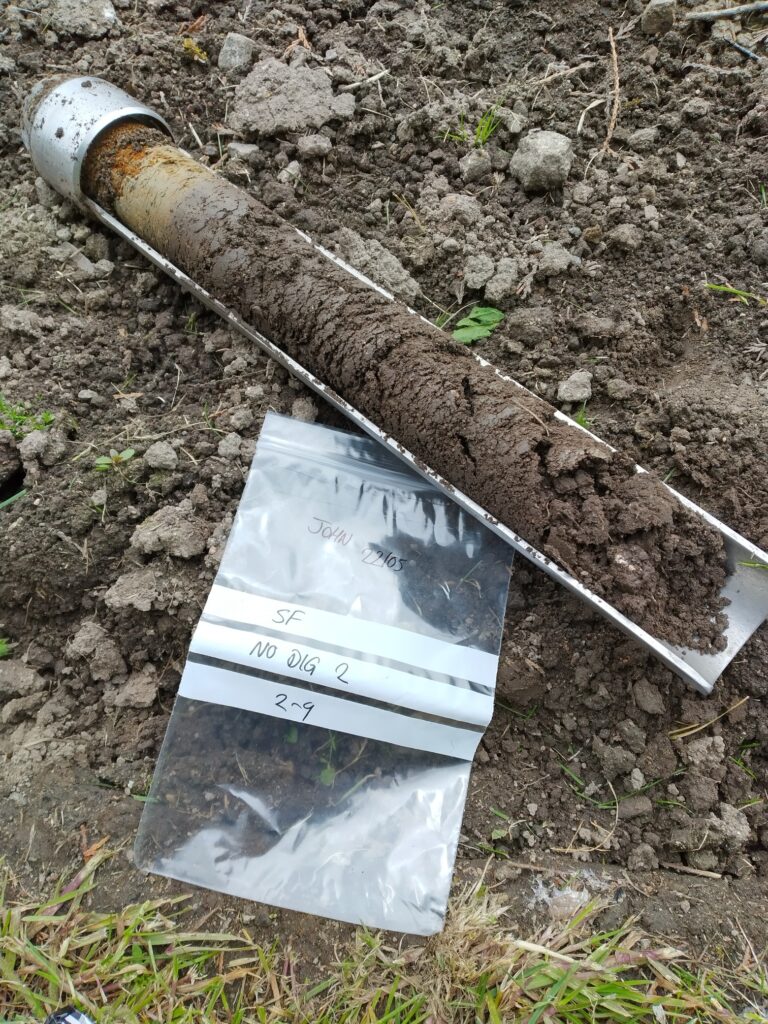 Soil auger with soil sample showing different layers in the soil